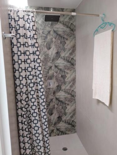 a shower with a shower curtain in a bathroom at Psi Nova in Baños