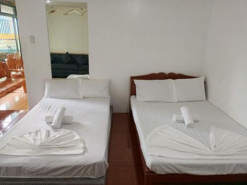 two beds sitting next to each other in a room at BuenaMaria Mountain Resort in Puerto Galera