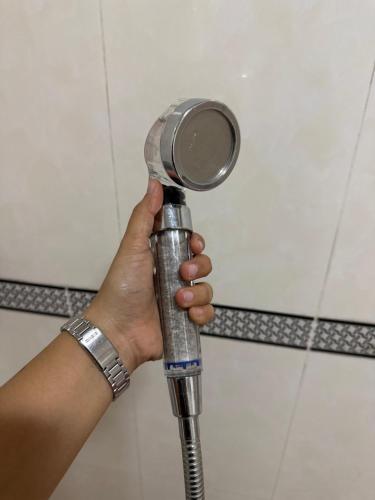 a person holding a hair dryer in a bathroom at Baguio BELL Staycation in Baguio