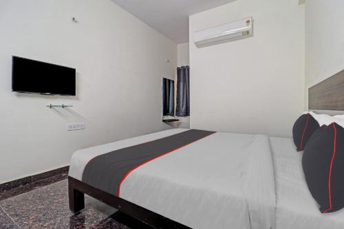 a bedroom with a large bed with a tv on the wall at Collection O SS Metro Ritz in Hyderabad