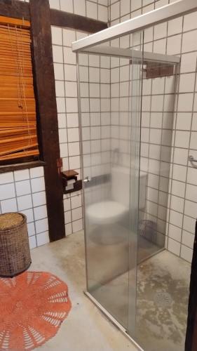 a glass shower in a bathroom with a window at Suite casa cachoeira in Paraty