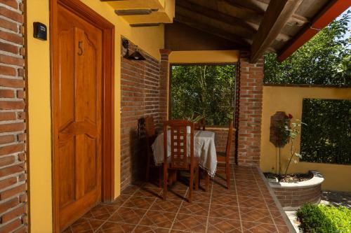 un patio con una porta, un tavolo e delle sedie di Cabañas Sierra Verde a Zacatlán