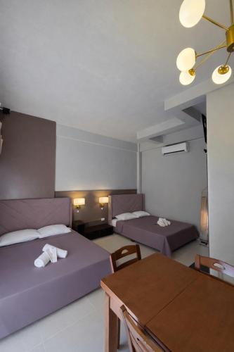 a room with two beds and a table and a dining room at Sundown Lodge in San Fernando