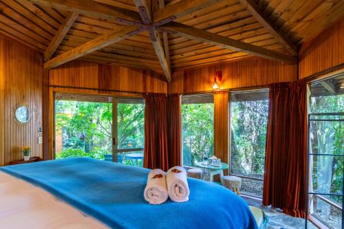 a bedroom with a bed with two pairs of slippers at Ora Retreat in Queenstown