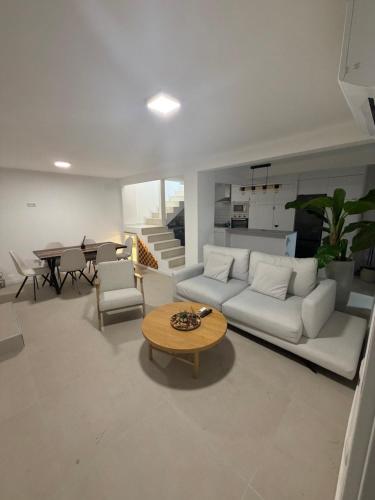 a living room with a white couch and a table at Jupiter 4 dormitorios 300 depósito in Alcorcón