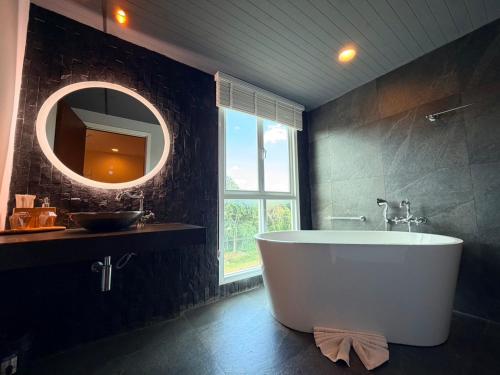 a bathroom with a large tub and a mirror at Mybed Chonburi in Ban Nong Tako