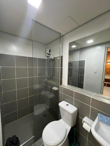 a bathroom with a toilet and a shower and a mirror at B1 4Magnificent in Puerto Princesa City