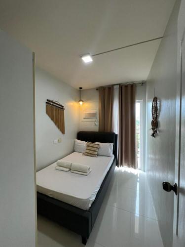 a bedroom with a bed with white sheets and pillows at B1 4Magnificent in Puerto Princesa City