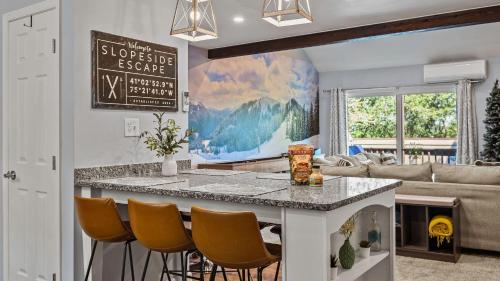 a kitchen and living room with a counter and chairs at Slopeside Escape by AvantStay Walk to Ski Lifts Arcade Games Shuffleboard in Tannersville