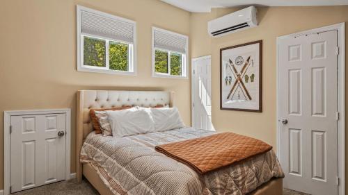 a bedroom with a bed and two windows at Slopeside Escape by AvantStay Walk to Ski Lifts Arcade Games Shuffleboard in Tannersville