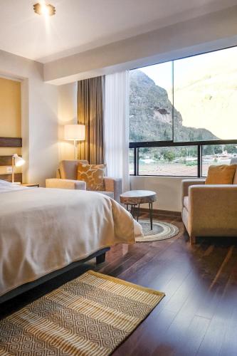 a hotel room with a bed and a large window at Ayra Hotel Boutique in Pisac