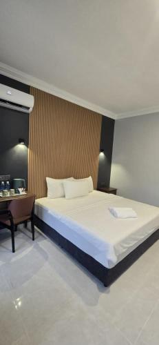 a bedroom with a large bed and a desk at TEBiNG Guest House Taman Negara Malaysia Kuala Tahan in Kuala Tahan