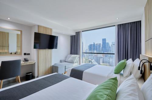 a hotel room with two beds and a window at The Four Wings Hotel Bangkok in Bangkok