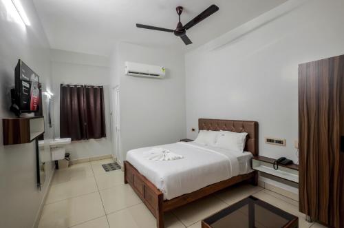a bedroom with a bed and a ceiling fan at Lee Rooms in Nāgercoil