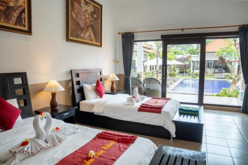a hotel room with two beds and a pool at Tulamben Dive Resort in Tulamben