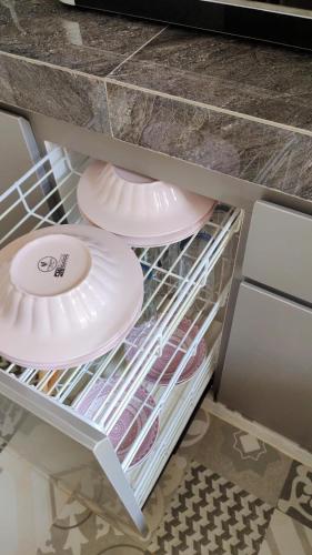 a refrigerator with plates and dishes on a shelf at patangpuluh homestay in Purwokerto