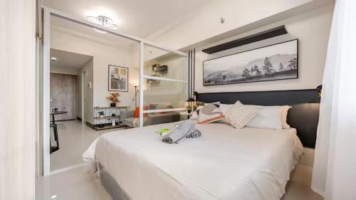 a bedroom with a large white bed with a large mirror at Kajas Condo Luxe at Primeworld District near Mactan-Cebu International Airport in Lapu Lapu City