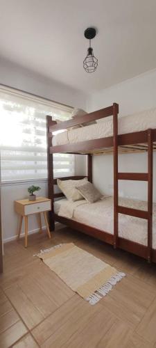 a bedroom with two bunk beds and a table at Cabañas Torres del Sol in Vicuña