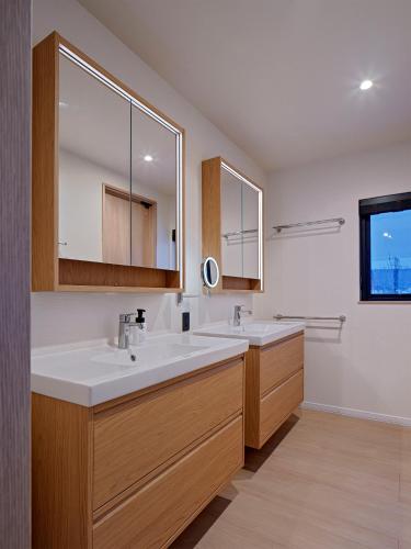 a bathroom with two sinks and a large mirror at Villa Matsu by H2 Life in Nakafurano