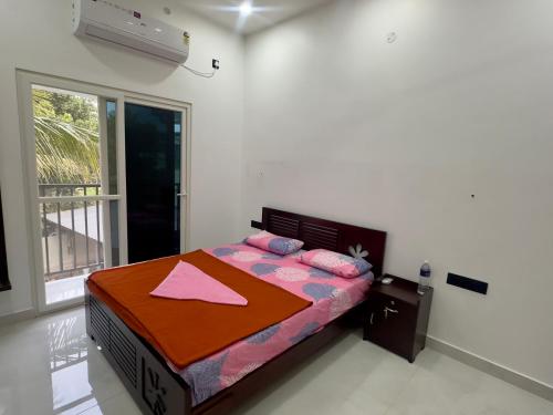 a bedroom with a bed in a room with a window at Nana's Residency, Cochin in Alwaye