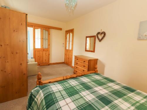 a bedroom with a bed and a dresser at Moybella Lodge in Ballybunion