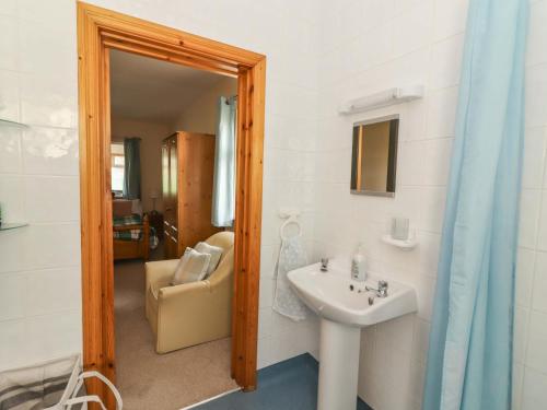 a bathroom with a sink and a chair at Moybella Lodge in Ballybunion