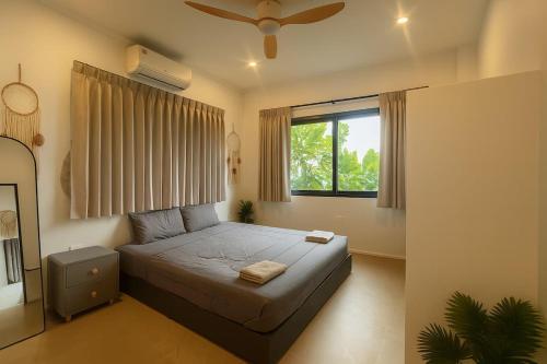 a bedroom with a bed and a window at Villa Narkis in Haad Yao
