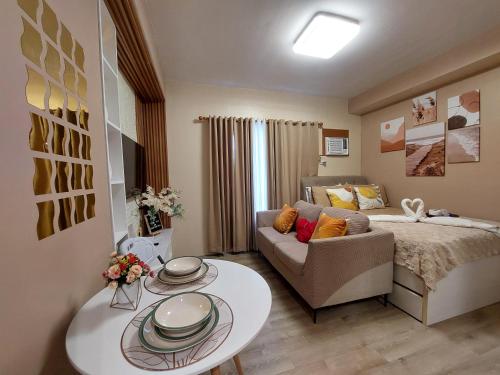 a small living room with a bed and a couch at Jade's Place Condo in Bacolod