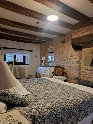 a bedroom with a bed and a stone wall at maison la Bambine chambre esprit château in Ozolles