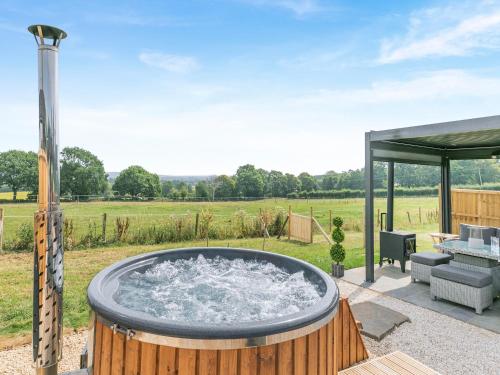 a hot tub in the middle of a yard at Barn Owl Lodge - Uk49903 in Appley Bridge