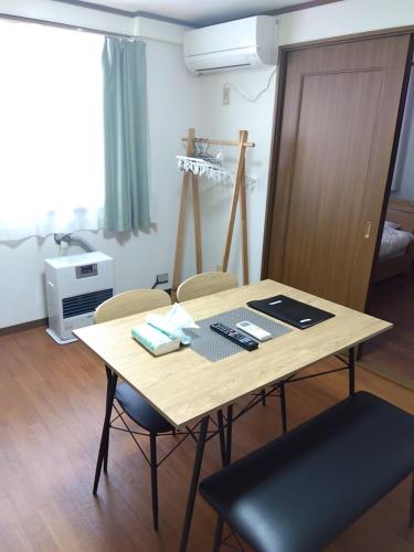 a wooden table with chairs in a room at メゾンジョイ久須志#101 in Asahimachi