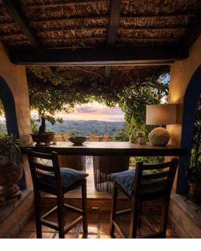 a porch with two chairs and a bar with a view at La Casa del Guamúchil in Tequesquitengo