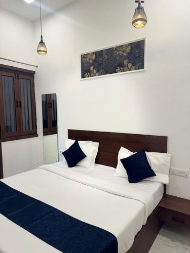 a bedroom with two beds with blue and white pillows at Jasmin A Luxury Stay-900m Walk To The Taj Mahal,Free Parking in Agra