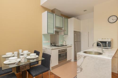 a kitchen with a table and a sink at SQSu in Tanjong Tokong