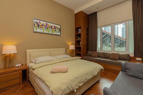 a bedroom with a large bed and a couch at SQSu in Tanjong Tokong