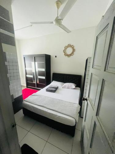 a bedroom with a bed and a ceiling fan at Homestay nakhoda Sitiawan in Lumut