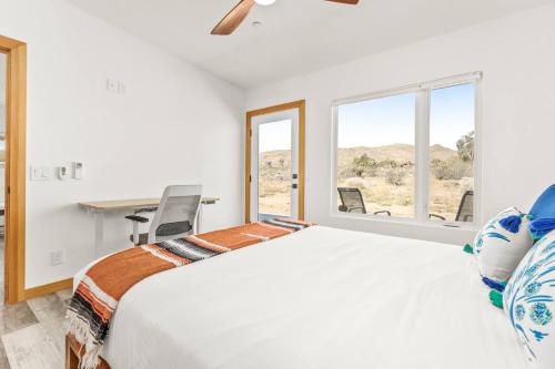 a bedroom with a bed and a desk and a window at Santorini with Stargazing - Views - Spa - Fire pit in Yucca Valley