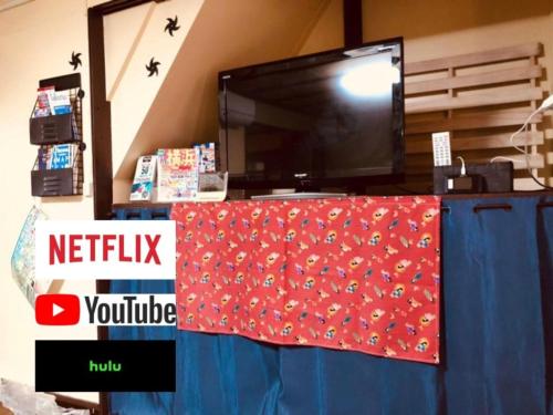 a tv sitting on top of a blue table with a red blanket at Yokohama Sakae-chou Ninja House #JA1 in Yokohama