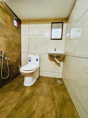 a bathroom with a toilet and a sink at Neelees Retreat in Kaniyāmbetta