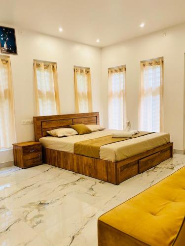 a bedroom with two beds and two windows at Neelees Retreat in Kaniyāmbetta