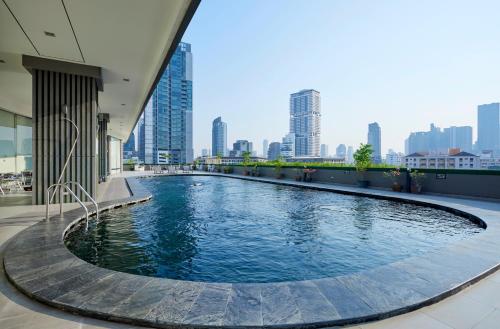 a swimming pool in a building with a city skyline at The Four Wings Hotel Bangkok in Bangkok