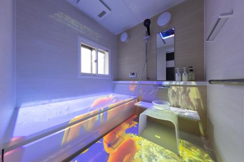 a bathroom with a fish tank and a sink at Tsuzumi Suite - Private Cinema & Immersive Stay in Kanazawa in Housai