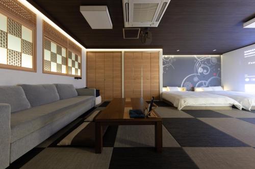 a living room with a couch and a bed at Tsuzumi Suite - Private Cinema & Immersive Stay in Kanazawa in Housai