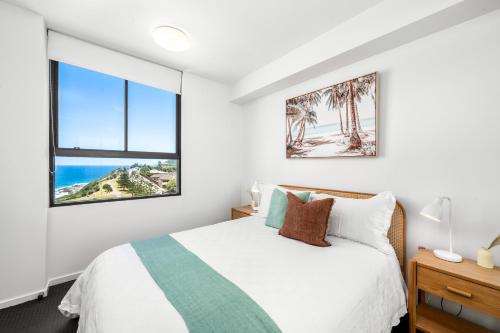 a bedroom with a bed and two windows at Seaside Luxe - L8 - Local Eats, Walks, Swims, CBD in Newcastle
