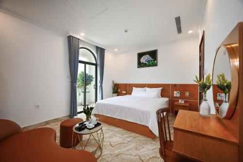 a hotel room with a bed and a table and a desk at Ly Ly Luxury Hotel in Ho Chi Minh City