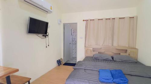 a bedroom with a bed and a flat screen tv at Thung Setthi Homestay&Cafe5 in Chiang Dao