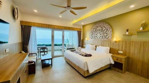 a bedroom with a large bed and a balcony at Solaluna Beach Homestay in Amed