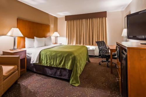 a hotel room with a bed and a flat screen tv at Quality Inn Tomah in Tomah