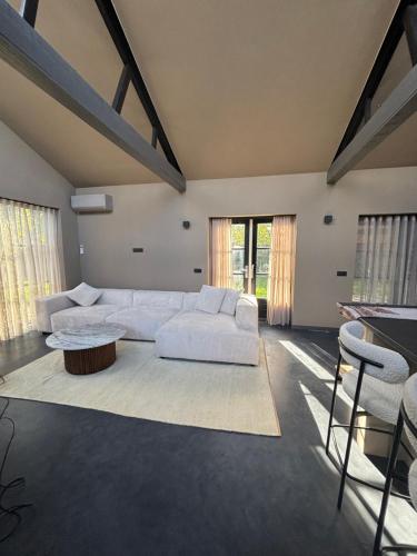 a living room with a white couch and a table at Schuurwoning in Weert