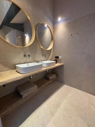 a bathroom with two sinks and two mirrors at Schuurwoning in Weert